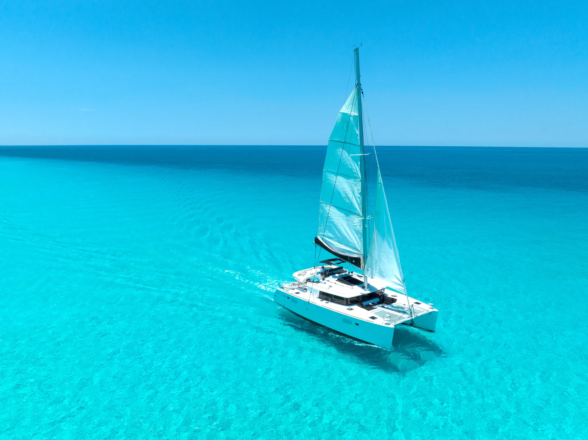 Luxury catamaran sailing in clear turquoise waters near Impression Isla Mujeres by Secrets.