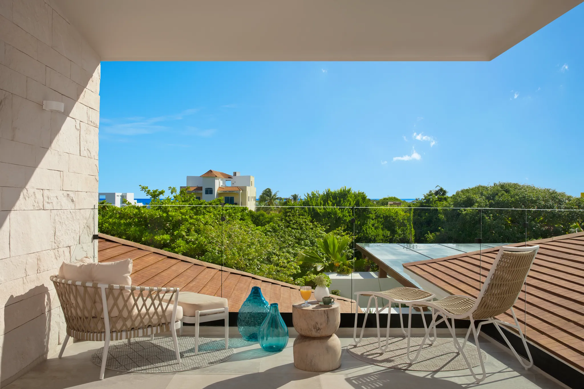 Junior Suite Double terrace with lounge seating and tropical view at Impression Isla Mujeres by Secrets.