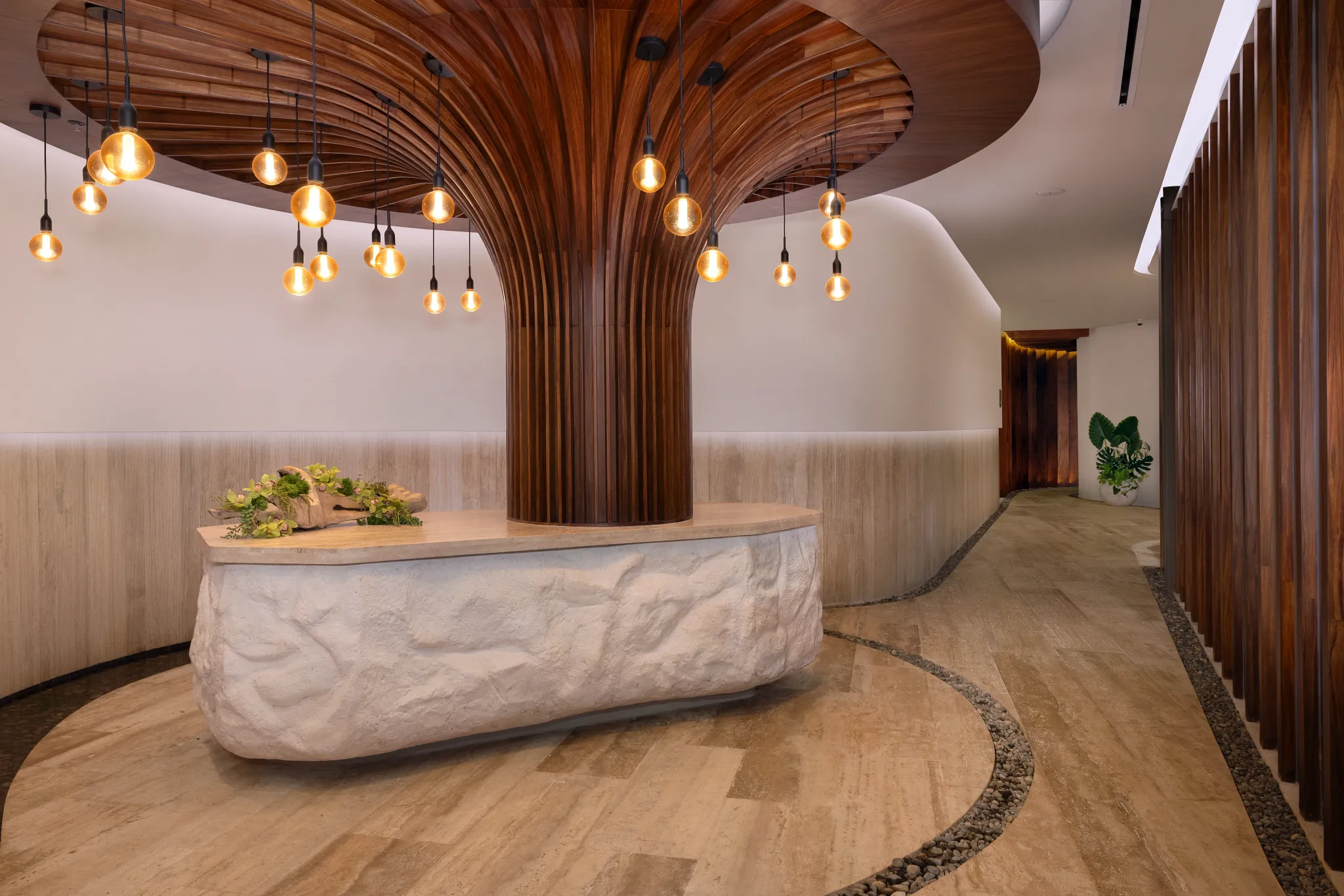 Spa reception area with sculptural wood ceiling and pendant lights at Impression Isla Mujeres by Secrets.