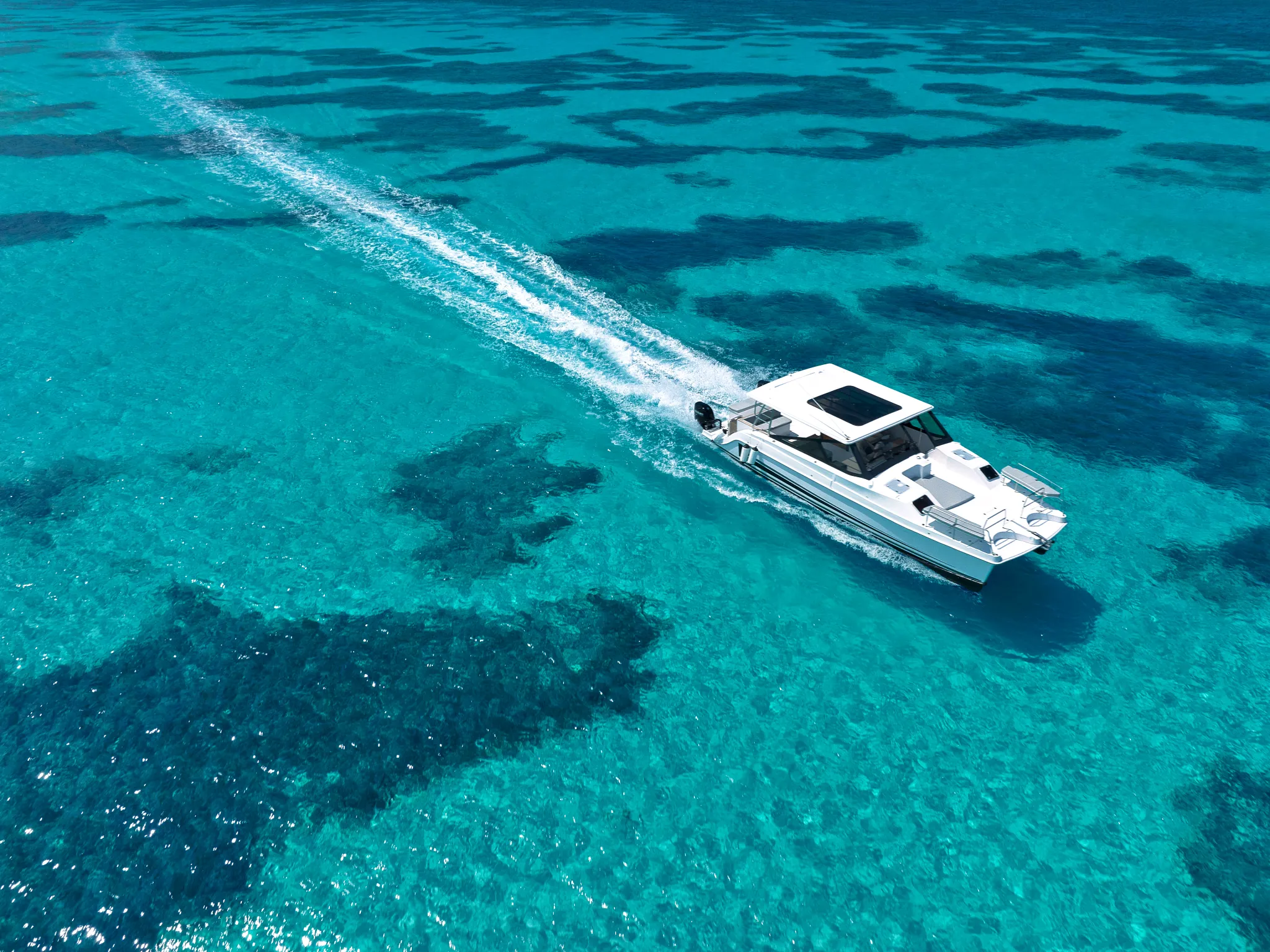 Speedboat cruising over clear turquoise water near Impression Isla Mujeres by Secrets.